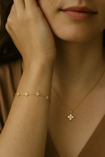 Load image into Gallery viewer, Model wearing the Floral Zircon Gold Bracelet with a matching necklace by MJ Luxe. This dainty bracelet features delicate floral zircon clusters on a fine gold chain, adding understated sparkle to any outfit. Lightweight, minimalist, and versatile, it can be worn daily or styled for special occasions. A timeless gold bracelet for women that makes an ideal bridesmaid gift, bridal accessory, or elegant jewellery gift for birthdays and anniversaries.