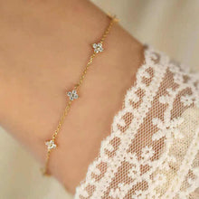 Load image into Gallery viewer, Floral Zircon Gold Bracelet by MJ Luxe worn on the wrist with a lace sleeve. This dainty gold bracelet features sparkling zircon stones in delicate floral motifs, creating an elegant minimalist design. Lightweight and versatile, it is perfect for everyday wear, stacking, or gifting. A timeless piece of jewellery for women, ideal as a bridesmaid gift, bridal accessory, or a thoughtful present for birthdays and anniversaries.
