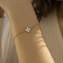Load image into Gallery viewer, Close-up of the Floral Zircon Gold Bracelet by MJ Luxe worn on the wrist. Featuring sparkling zircon stones arranged in dainty floral motifs on a fine gold chain, this minimalist bracelet offers understated elegance for any occasion. Lightweight and versatile, it can be styled solo or stacked with other jewellery. A timeless gold bracelet for women, perfect as a bridesmaid gift, bridal accessory, or everyday minimalist jewellery piece.