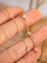 Load image into Gallery viewer, Close-up of the Floral Zircon Gold Bracelet by MJ Luxe held in hand. This dainty bracelet features small zircon stones set in floral motifs on a fine gold chain, creating a modern yet timeless look. Lightweight and delicate, it is perfect for everyday wear or layering with other MJ Luxe favourites. An elegant piece of minimalist gold jewellery that makes a beautiful bridesmaid gift, bridal accessory, or meaningful jewellery gift for women.
