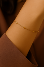 Load image into Gallery viewer, Minimalist gold bead bracelet styled on wrist, elegant women’s jewellery perfect for everyday wear or layering with other MJ Luxe favourites.
