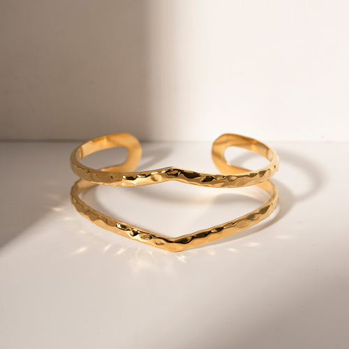 Elegant hammered double cuff bracelet in waterproof 18K gold plated stainless steel, photographed on a white background. Features a handcrafted hammered texture with a sculptural double-band design. Minimalist yet bold jewellery piece perfect for everyday wear, stacking with bangles, or gifting as a timeless bracelet. Durable, tarnish-resistant, and designed for women who love chic, modern jewellery.