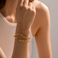 Load image into Gallery viewer, Model wearing the MJ Luxe hammered double cuff bracelet in 18K gold plating. Features a modern open cuff with hammered detailing and a bold double-band silhouette. Perfect for layering with other bracelets or wearing alone as a statement piece. Adjustable fit ensures comfort for most wrist sizes. Elegant minimalist jewellery ideal for everyday wear, special occasions, or as a thoughtful gift for women.
