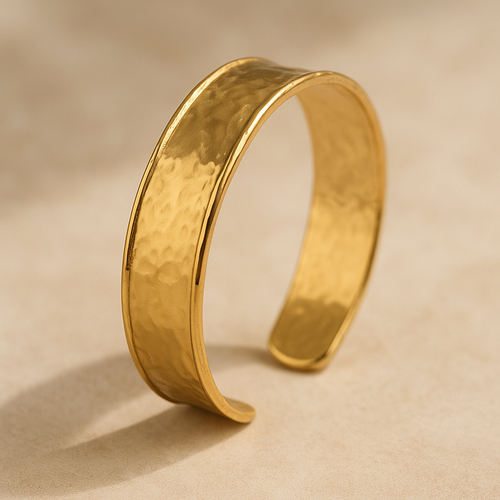 MJ Luxe Co Colette Gold Textured Cuff Bracelet with a hammered finish displayed on a neutral stone background. This adjustable open cuff bangle is crafted in 18K gold plated stainless steel with PVD coating, making it waterproof, tarnish resistant, hypoallergenic, and nickel free. A minimalist yet elegant gold bracelet perfect for everyday wear, stacking, or gifting as bridal and bridesmaid jewellery
