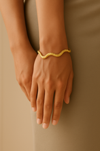 Load image into Gallery viewer, Model wearing MJ Luxe Hammered Gold Wave Cuff Bracelet, adjustable sculptural bangle with hammered gold texture, styled on wrist.

