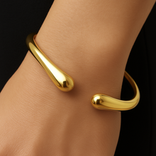 Load image into Gallery viewer, Close-up of MJ Luxe Ava Gold Cuff Bracelet, sculptural teardrop ends and polished gold finish, modern adjustable open bangle.
