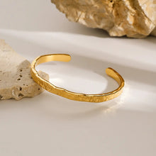 Load image into Gallery viewer, Aurora Hammered Gold Cuff Bracelet displayed on stone background, elegant textured gold bangle designed for everyday wear, waterproof and durable fashion jewelry piece.
